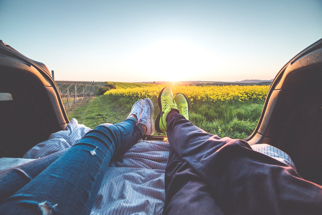 jeune couple regardant un paysage dans leur voiture